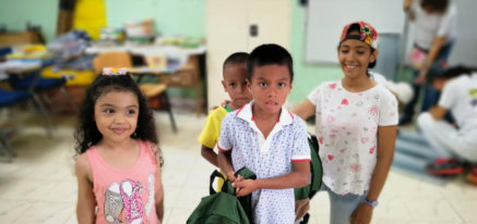 Kids showing off their new backpacks